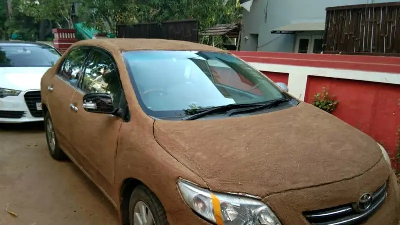 wanita india lapisi mobil dengan kotoran sapi