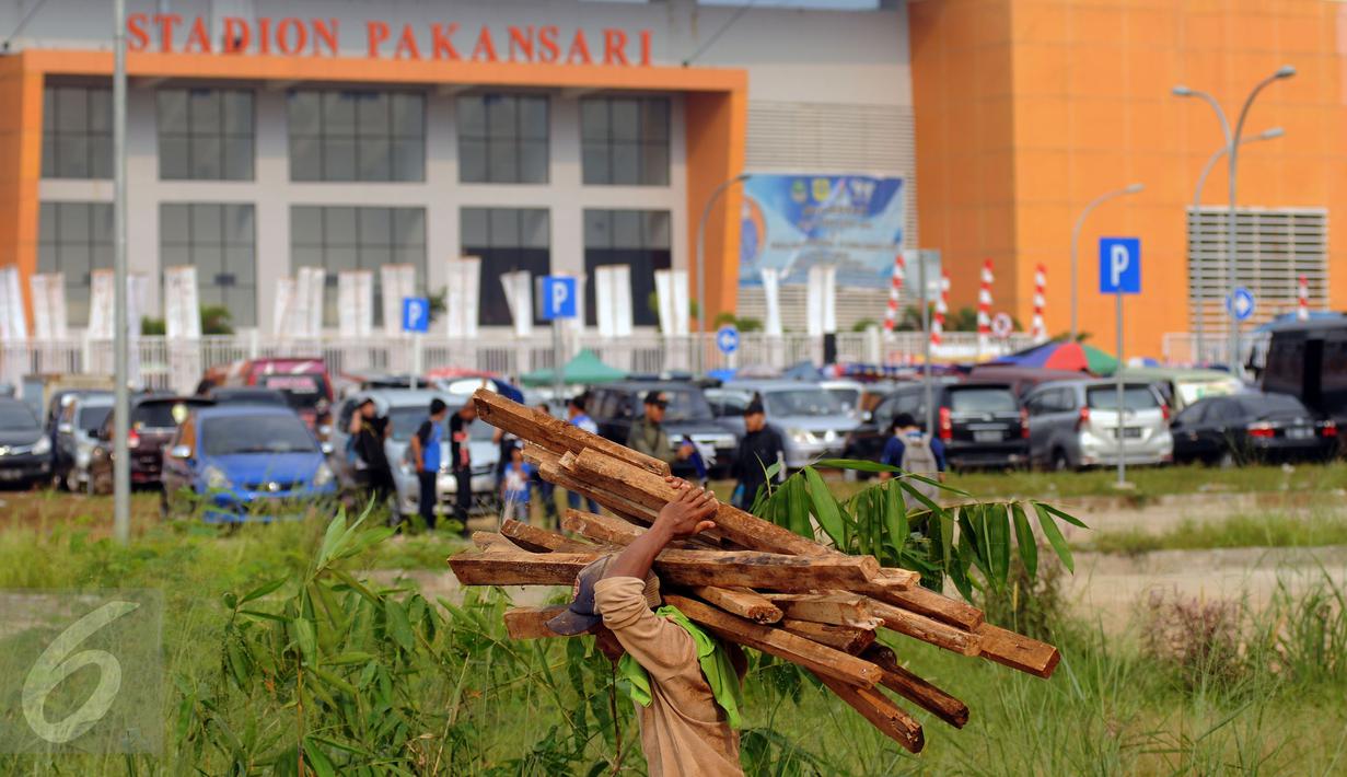 Pekerja mengangkut sisa material bangunan di luar Stadion Pakansari, Kabupaten Bogor, Minggu (21/8). Jelang pelaksanaan PON XIX Jawa Barat, pembangunan sarana pertandingan di Stadion Pakansari terus dikerjakan. (Liputan6.com/Helmi Fithriansyah)