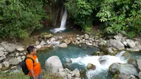 Sungai Lau Mentar. Airnya sangat jernih, mengalir di antara dinding-dinding batu besar, serta permukaannya yang tampak berwarna biru kehijauan berpadu dengan rimbunnya pepohonan di sepanjang aliran sungai