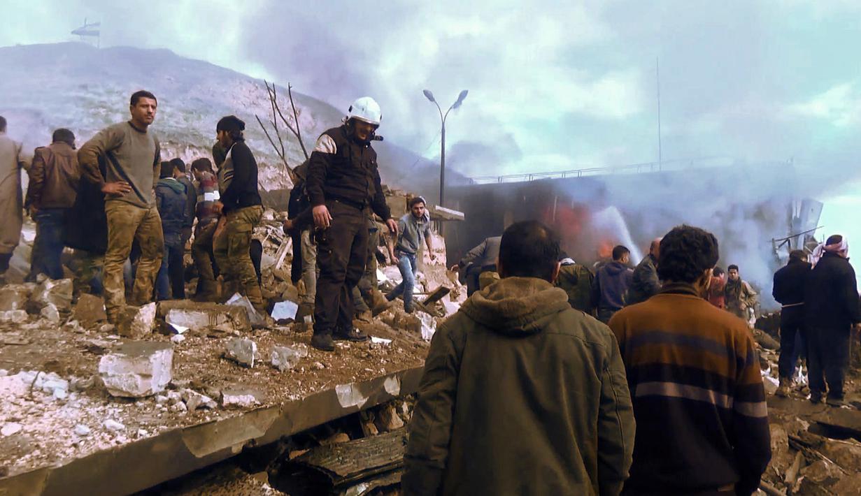 Warga berkumpul di lokasi ledakan truk tangki pengangkut BBM di sebuah pasar di kota Azaz, perbatasan Suriah dan Turki, Sabtu (7/1). Para pemberontak menyebut ISIS berada di balik serangan yang terjadi di tengah gencatan senjata itu. (STRINGER/AFPTV/AFP)