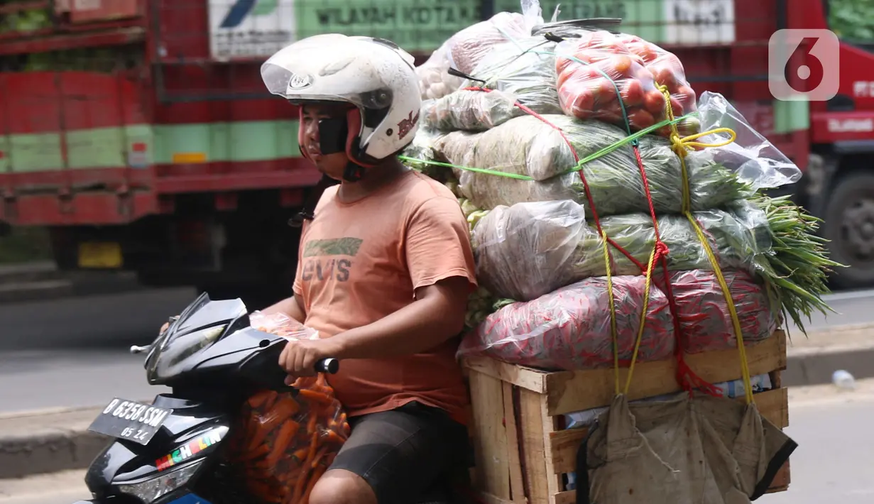 Warga membawa bahan makanan dengan sepeda motor saat melintas di kawasan Tangerang, Banten, Rabu (16/2/2022).Bank Indonesia (BI) memperkirakan terjadi penurunan harga komoditas atau deflasi pada Februari 2022. (Liputan6.com/Angga Yuniar)