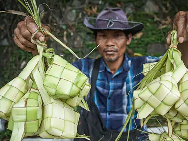 Seorang pedagang menunjukkan kulit ketupat saat menunggu pembeli di Jakarta, Sabtu (30/4/2022). H-2 Lebaran 2022 penjualan kulit ketupat mengalami peningkatan dengan harga jual Rp 6 ribu untuk 10 lembar atau bahan dan Rp 10 ribu untuk harga perikat. (Liputan6.com/Faizal Fanani)
