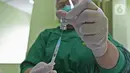 Petugas vaksinator menyiapkan vaksin CoronaVac dari SinoVac di RSUD Cengkareng, Jakarta, Kamis (14/01/2021). Vaksinasi Covid-19  tahap awal dijadwalkan berlangsung dari Januari hingga Februari 2021. (Liputan6.com/Herman Zakharia)