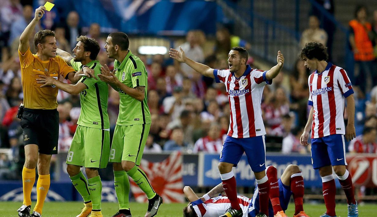 Wasit Felix Brych, memberikan kartu kuning kepada pemain Juventus, Leonardo Bonucci, saat pertandingan antara Juventus melawan Atletico Madrid pada laga liga Champion di Stadion Vicente Calderon (01/10/2014). (EPA/Juanjo Martin)