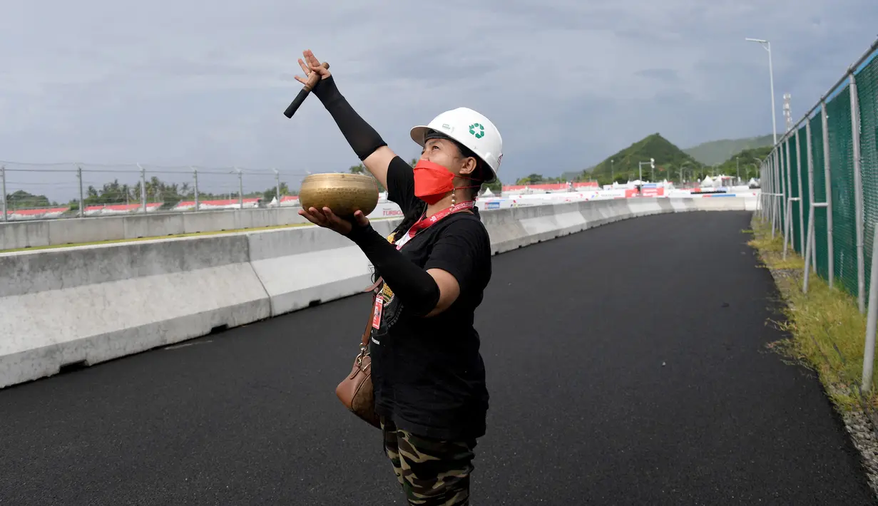 Seorang wanita melakukan ritual tradisional untuk cuaca baik saat sesi latihan MotoGP Mandalika 2022 di Pertamina Mandalika International Street Circuit, Mandalika, Lombok Tengah, Nusa Tenggara Barat, Jumat (18/3/2022). (SONY TUMBELAKA/AFP)