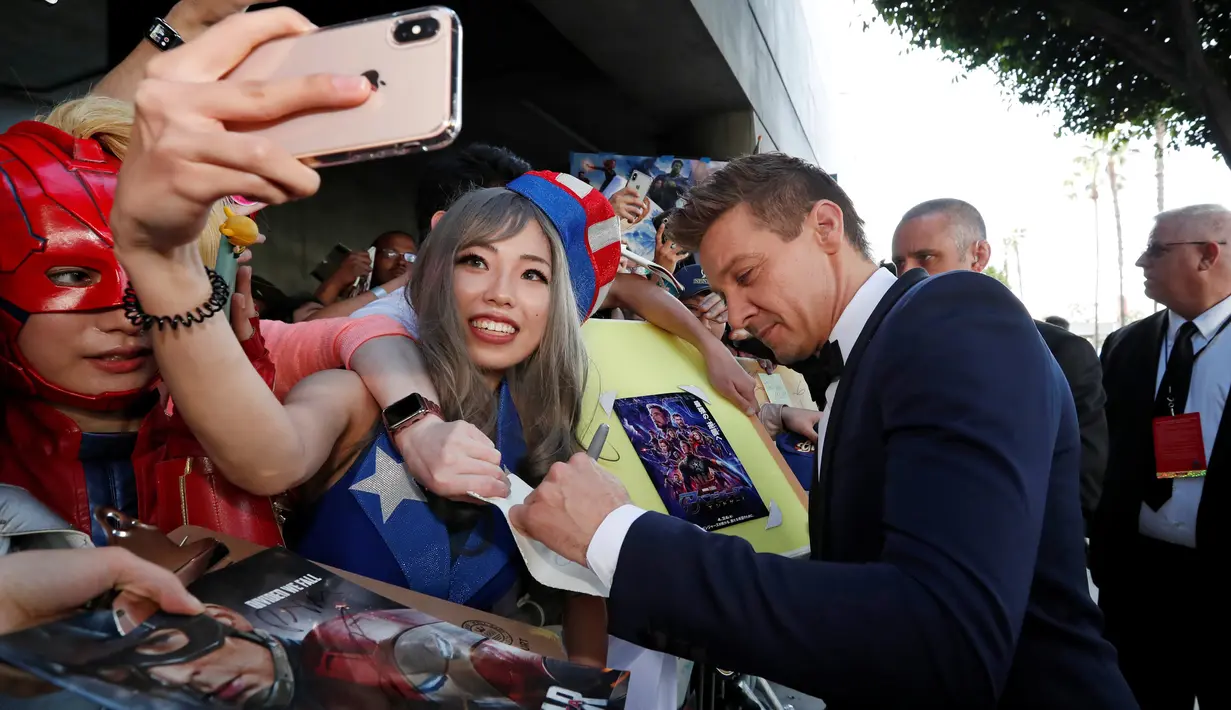 Jeremy Renner yang memainkan peran Hawk berswafoto dengan penggemar setibanya pada world premiere film Avengers: Endgame di Los Angeles, California, Selasa (23/4). Avengers: Endgame akan tayang mulai 26 April di Amerika dan 24 April besok di Indonesia. (REUTERS/Mario Anzuoni)