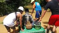 Warga korban banjir Konawe Utara yang mencari penyedia gas LPG 3 kilogram di tengah banjir.(Liputan6.com/Ahmad Akbar Fua)