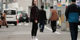 Gaya santai, namun tetap memesona ala Luna Maya saat berada di Jepang. Ia mengenakan kaus bercorak garis hitam-putih, yang dilayer dengan kemeja lengan panjang berwarna wine, ditambah sleeveless puffer jacket hitam. Ia padukan gayanya dengan legging hitam dan sneakers putih. Foto: Instagram.