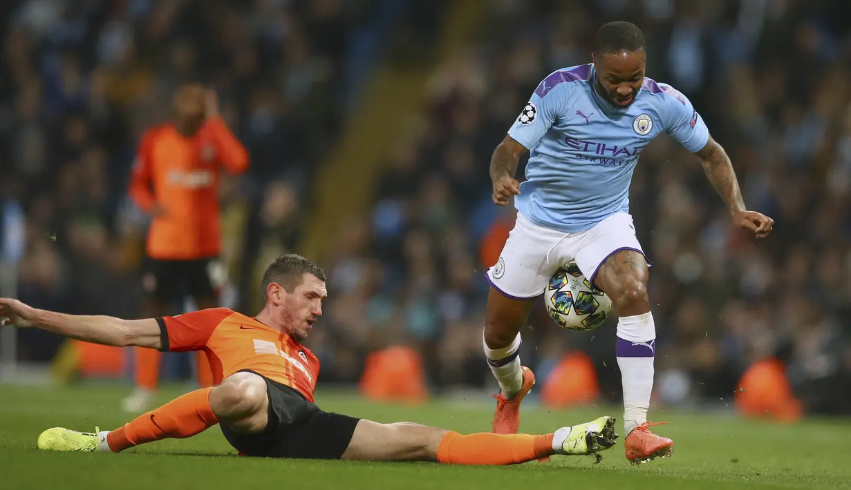 Penyerang Manchester City, Raheem Sterling berusaha melewati bek Shakhtar Donetsk, Serhiy Kryvtsov pada pertandingan Grup C Liga Champions di Stadion Etihad, Inggris (26/11/2019). Manchester City bermain imbang 1-1 atas Shakhtar Donetsk. (AP Photo/Dave Thompson)