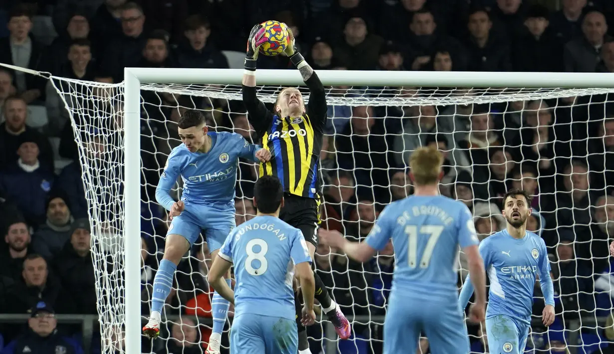Kiper Everton, Jordan Pickford (tengah) melakukan penyelamatan di depan pemain Manchester City Phil Foden (kiri) selama pertandingan lanjutan Liga Inggris di Goodison Park di Liverpool, Inggris, Minggu (27/2/2022). Man City menang tipis atas Everton 1-0. (AP Photo/Jon Super)