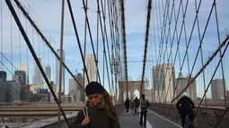 Orang-orang berjalan melintasi Jembatan Brooklyn di New York, 3 Desember 2018. Jembatan itu menjadi salah satu tujuan turis, lokasi pembuatan film maupun warga kota yang hendak menikmati suasana Brooklyn-Manhattan dari sisi berbeda. (AP/Wong Maye-E)