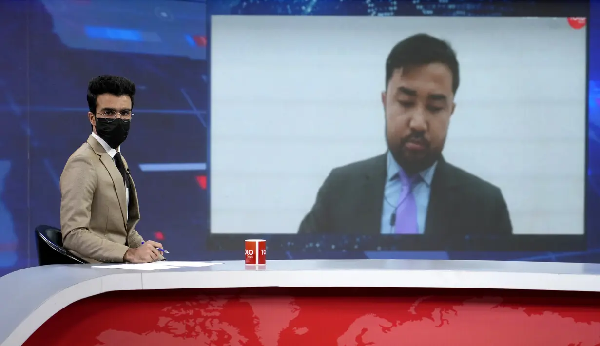 <p>Pembawa acara TV Hamed Bahram mengenakan masker untuk memprotes perintah baru Taliban bahwa presenter perempuan harus menutupi wajah mereka, saat membaca berita di TOLOnews, di Kabul, Afghanistan, Minggu, 22 Mei 2022. Dalam aksi solidaritas dengan rekan-rekan wanita, pembawa berita pria saluran itu menutupi wajah mereka dengan masker, termasuk pembaca berita malam utama. (AP Photo/Ebrahim Noroozi)</p>