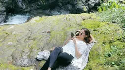 Santai menikmati sausana alam di sekitaran curug, pemain sinetron Ikatan Cinta ini nyaman tiduran di atas batu. Tampil dengan busana kasual, sosoknya tetap terlihat manawan. Tidak sedikit netizen yang memuji penampilannya di kolom komentar Instagramnya. (Liputan6.com/IG/@glencachysaraofficial)