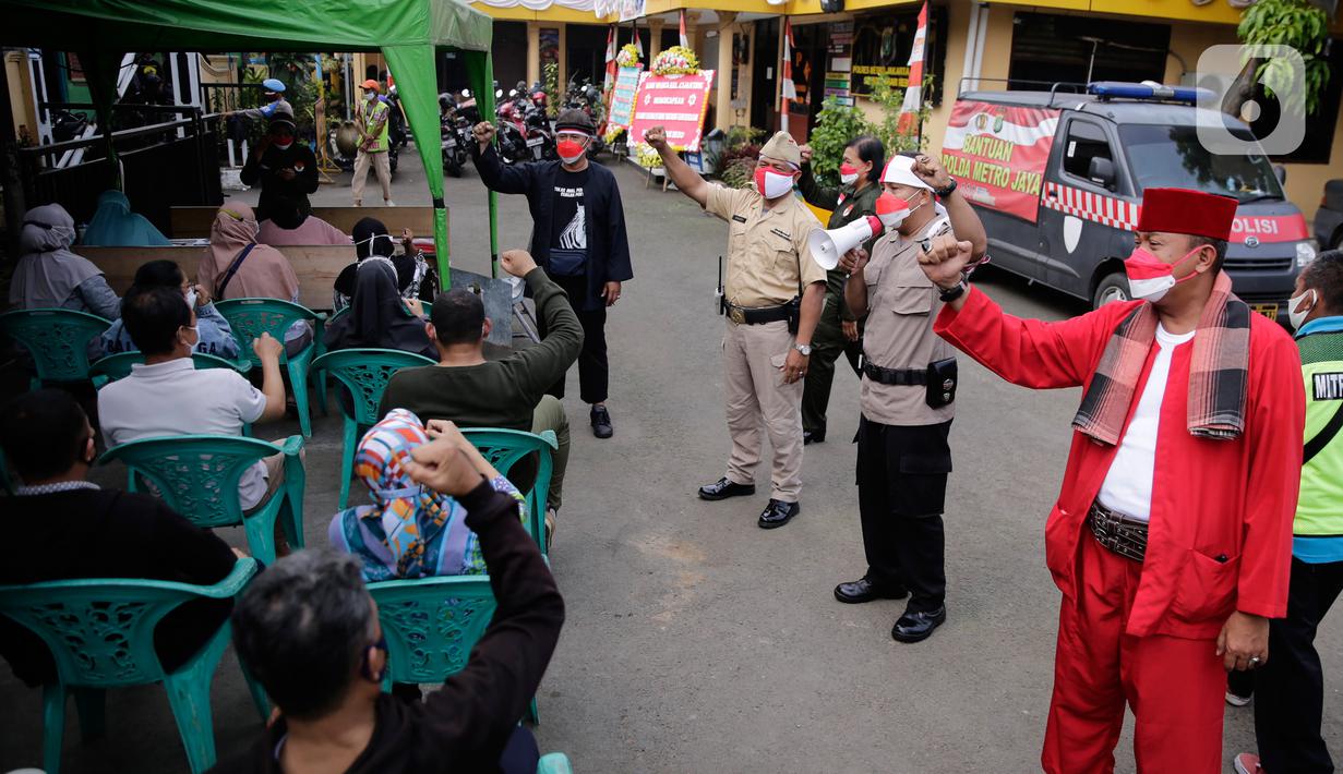 Petugas kepolisian berpakaian pejuang jaman dulu saat memberikan pengarahan kepada warga yang akan ikut vaksin Covid-19 di Polsek Pasar Rebo, Jakarta, Selasa (17/8/2021). Para petugas berkostum pejuang jaman dulu memeriahkan HUT ke-76 Republik Indonesia. (Liputan6.com/Angga Yuniar)