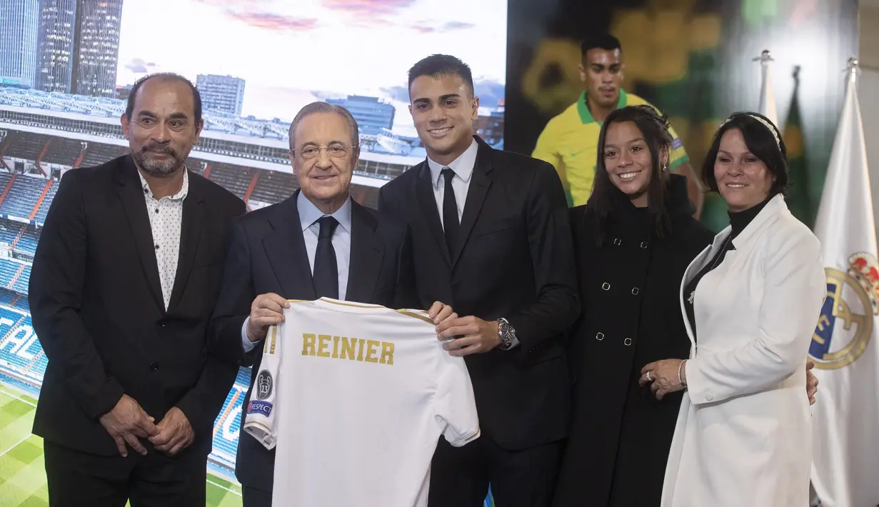 Gelandang baru Real Madrid, Reinier Jesus berpose dengan Presiden Florentino Perez dan anggota keluarganya selama presentasi dirinya di stadion Santiago Bernabeu di Madrid, Spanyol, Selasa, (18/2/2020). (AP Photo/Paul White)