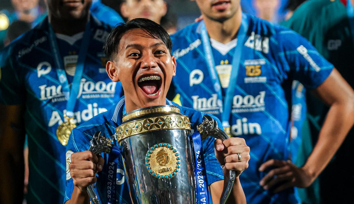 Selebrasi gelandang Persib Bandung, Beckham Putra dengan trofi juara setelah mengalahkan Madura United 3-1 pada laga leg kedua final Championship Series BRI Liga 1 2023/2024 di Stadion Gelora Bangkalan, Madura, Jumat (31/5/2024). (Bola.com/Bagaskara Lazuardi)