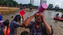 Warga melakukan tradisi keramas bersama di Sungai Cisadane di Kampung Babakan, Tangerang, Selasa (21/3/2023). (Liputan6.com/Angga Yuniar)