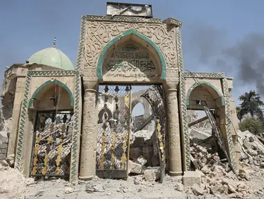 Gerbang Masjid Agung al-Nuri hancur akibat peperangan antara pasukan pemerintah Irak dan kelompok militan ISIS, di Kota Tua Mosul, 30 Juni 2017. Masjid yang dibangun abad ke-12 itu rata dengan tanah usai diledakkan kelompok ISIS. (AHMAD AL-RUBAYE/AFP)