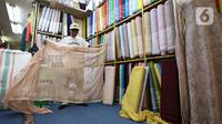 Pedagang menata kain bahan di Pasar Tanah Abang, Jakarta, Rabu (18/5/2022). Kementerian Perindustrian memproyeksikan industri tekstil dan produk tekstil (TPT) bakal tumbuh 3,5 persen pada semester I/2022. (Liputan6.com/Angga Yuniar)