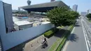 Pesepeda melintas dekat Olympic Aquatics Center selama tur media ke sejumlah venue Olimpiade Tokyo 2020 di Tokyo, Selasa (17/7). Nantinya cabang Olahraga akuatik termasuk berenang, menyelam dan renang artistik akan berlangsung di sini. (AP/Eugene Hoshiko)