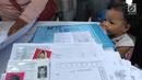 Seorang anak menyaksikan pembuatan Kartu Identitas Anak (KIA) yang digelar Disdukcapik Kota Depok di Kantor Kecamatan Cinere, Depok, Jawa barat, Rabu (2/10/2019). Ratusan emak-emak menyerbu pelayanan gratis ini sebagai syarat administrasi anak masuk tahun ajaran baru. (merdeka.com/Arie Basuki)