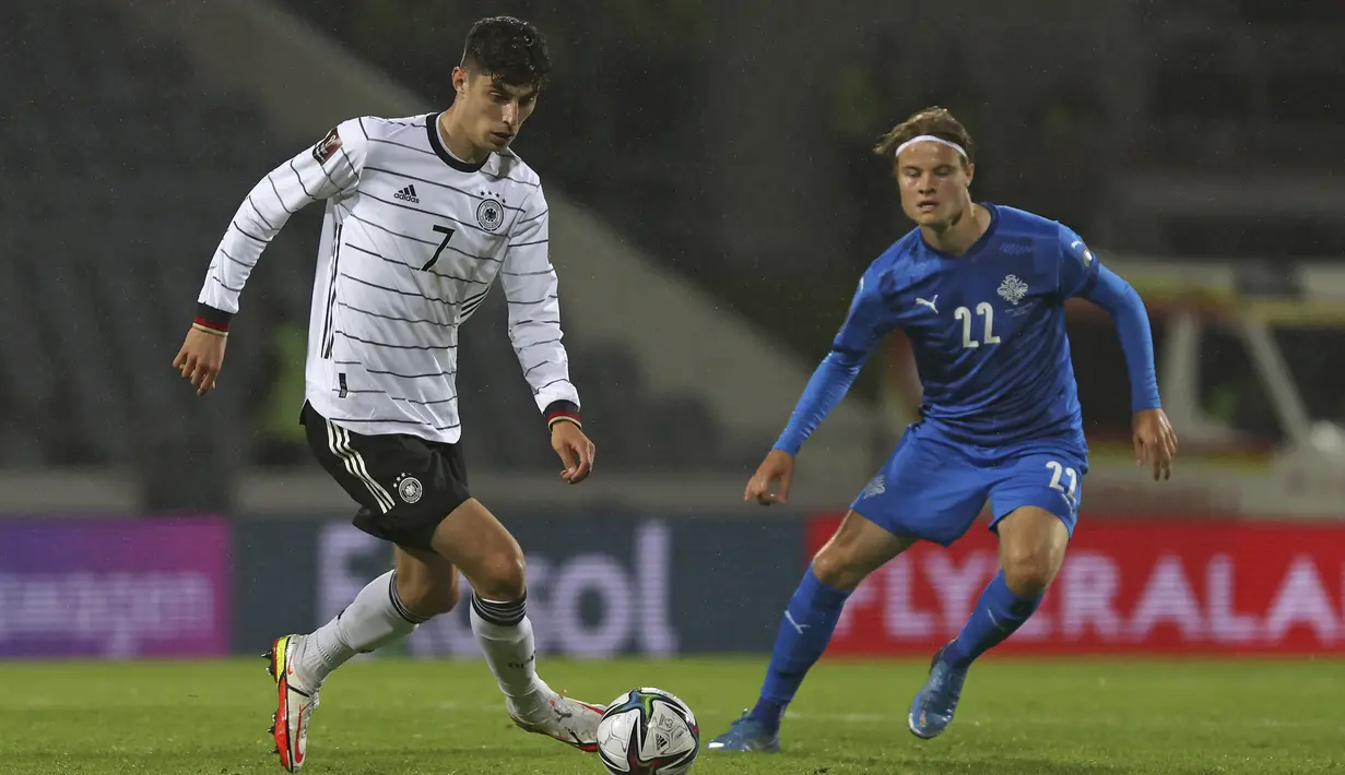 Gelandang Jerman, Kai Havertz membawa bola dari kawalan pemain Islaandia, Lucas Gudjohnsen dalam lanjutan laga kualifikasi grup J Piala Dunia 2022 di Reykjavik, Islandia, Kamis (9/9/2021). Kemenangan ini membuat Jeman nyaman di puncak klasemen Grup J dengan poin 15. (AP Photo/Arni Torfason)