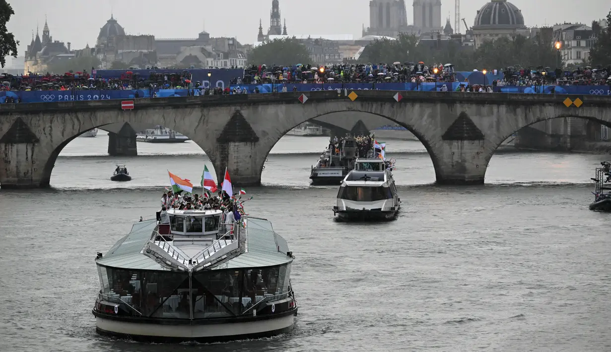 Kapal yang membawa kontingan Indonesia menyusuri sungai Seine saat pembukaan Olimpiade Paris 2024 di Paris, Prancis, Kamis (26/7/2024). (SEBASTIEN BOZON / AFP)