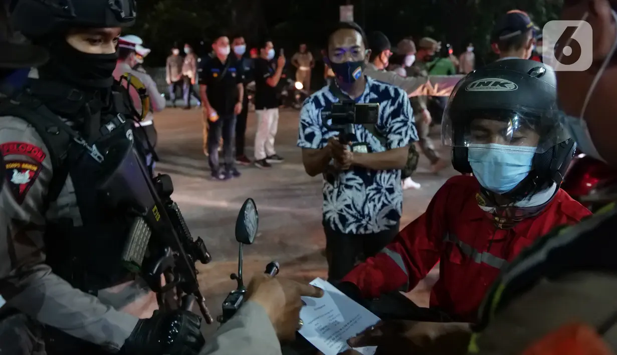 Polisi memeriksa dokumen pengendara yang melintas di posko penyekatan mudik di Kedungwaringin, Kabupaten Bekasi, Senin (10/5/2021). Pada H-3 menjelang Idul Fitri 1442 H, jumlah petugas yang berjaga di pos penyekatan pemudik di Kedungwaringin ditambah sebanyak 150 orang (Liputan6.com/Herman Zakharia)