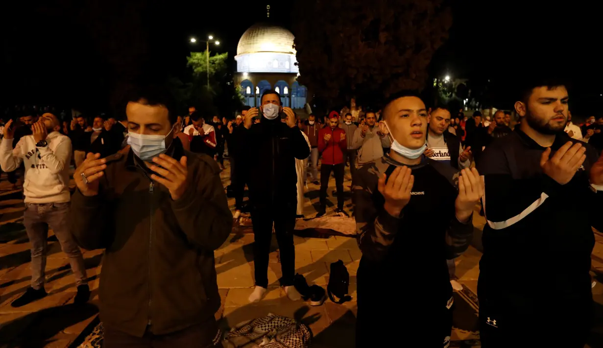 Muslim Palestina berdoa di kompleks masjid al-Aqsa, situs paling suci ketiga bagi umat Islam, di Yerusalem, Minggu (31/5/2020). Kompleks masjid Al-Aqsa resmi kembali dibuka hari ini, Minggu (31/5) setelah ditutup dua bulan sebagai bagian upaya memutus penularan virus corona. (Ahmad GHARABLI/AFP)