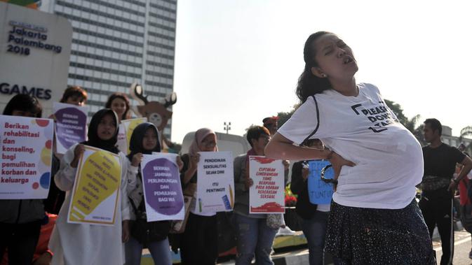 Massa saat menggelar aksi teatrikal menuntut keadilan untuk WA korban pemerkosaan, Jakarta, Minggu (5/8). Massa juga menggelar pembubuhan tanda tangan sebagai bentuk dukungan untuk WA yang dipenjara karena melakukan aborsi. (Merdeka.com/Iqbal S. Nugroho)