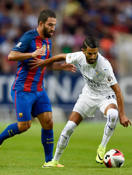 Gelandang Leicester City, Riyad Mahrez berusaha membawa bola dari kejaran gelandang Arda Turan di International Champions Cup di Friends Arena, Stockholm, Swedia, (4/8). Barcelona menang atas Leicester dengan skor 4-2. (Reuters/Adam Holt)