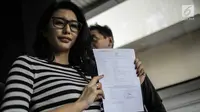 Artis peran Tyas Mirasih menunjukkan surat laporan pencemaran nama baik usai melapor ke Polda Metro Jaya, Jakarta, Rabu (21/3). Sebelumnya, Tyas dituduh menculik anak perempuan berusia lima tahun berinisial ACB. (Liputan6.com/Faizal Fanani)