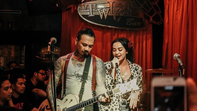 Jerinx SID mengiringi lantunan suara sang istri, Nora Alexandra usai keluar dari penjara. Terlihat wajah Nora yang bahagia bisa manggung bareng suami. (Foto: Instagram/@ncdpapl)