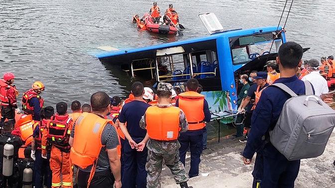 Tim penyelamat berkumpul di lokasi sebuah bus yang jatuh ke danau di Anshun, China, Selasa (7/7/2020). Sedikitnya 21 orang tewas usai bus yang membawa siswa untuk mengikuti ujian masuk perguruan tinggi (gaokao) itu menabrak pagar pembatas lalu tercebur ke danau (Long Rui/Xinhua via AP)