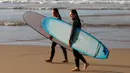 Peselancar bersiap bermain di Pantai Bondi di Sydney, Selasa, (28/4/2020). Mereka tetap wajib menerapkan jaga jarak sosial (physical distancing) karena corona belum benar-benar dapat dihentikan penyebarannya di negara tersebut. (AP Photo/Rick Rycroft)