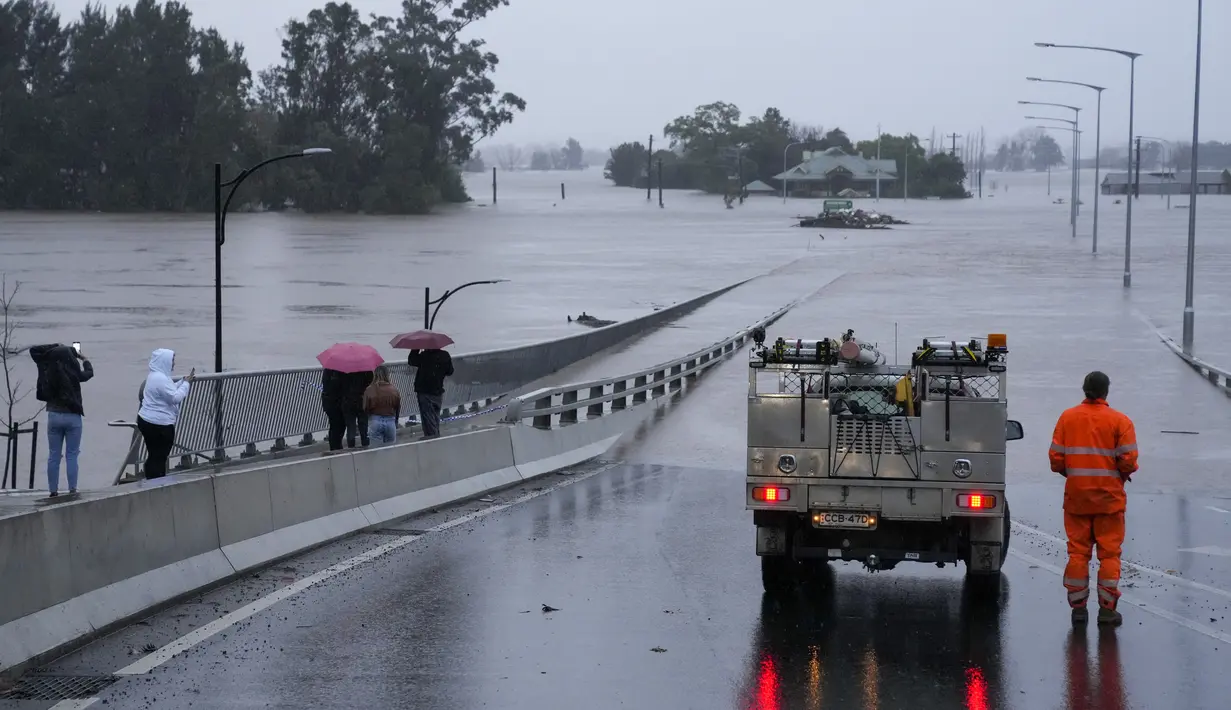 Sebuah kendaraan darurat memblokir akses ke Jembatan Windsor yang banjir di pinggiran Sydney, Australia, Senin (4/7/2022). Ratusan rumah terendam di dalam dan sekitar kota terbesar Australia itu dalam keadaan darurat banjir yang berdampak pada 50.000 orang, kata para pejabat. (AP Photo/Mark Baker)