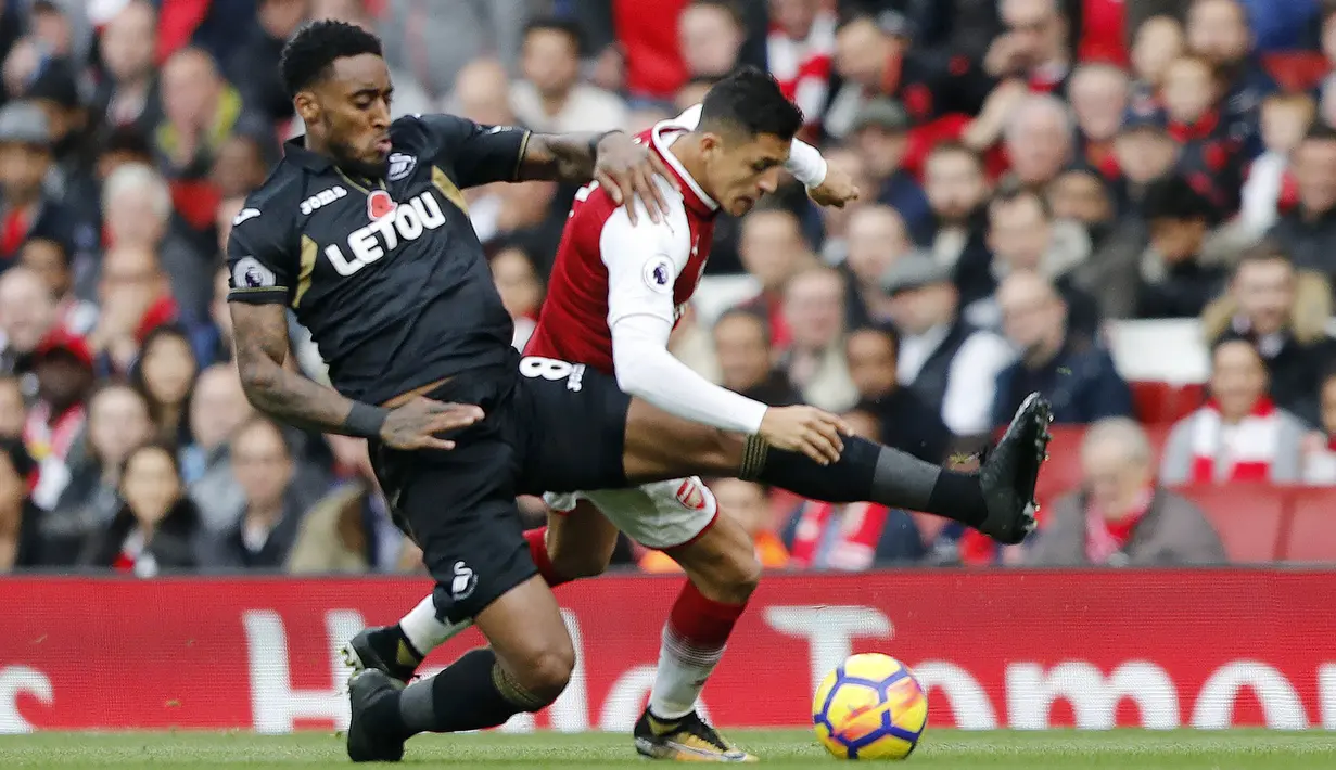 Striker Arsenal, Alexis Sanchez, berebut bola dengan gelandang Swansea City, Leroy Fer, pada laga Premier League di Stadion Emirates, Sabtu (28/10/2017). Arsenal menang 2-1 atas Swansea City. (AP/Frank Augstein)