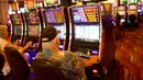 Seorang pria lansia bermain mesin slot di Dover Downs Casino, Delaware (5/6). Legalisasi ini dilakukan sejak keputusan Mahkamah Agung yang mencabut larangan federal setelah 25 tahun lalu. (Mark Makela/Getty Images North America/AFP)