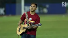 Salah satu suporter memainkan gitar akustik mengiringi nyanyian pendukung tim Macan Kemayoran usai menyaksikan laga Persija melawan Persipura di Stadion Patriot Candra Bhaga, Bekasi, Sabtu (8/7). (Liputan6.com/Helmi Fithriansyah)