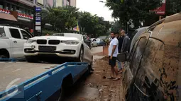 Sebuah mobil mewah dievakuasi setelah terjebak banjir di basement sebuah pertokoan di Jalan Kemang Raya, Minggu (28/8). Sejumlah kendaraan terendam air di kawasan Kemang pasca hujan deras di Jakarta, Sabtu (27/8). (Liputan6.com/Helmi Fithriansyah)
