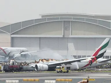 Petugas pemadam kebakaran menyemprotkan air ke pesawat Emirates Airline yang hangus terbakar di Bandara Internasional Dubai, UEA, Rabu (3/8).Kecelakaan ini saat pesawat mencoba mendarat. (Reuters)