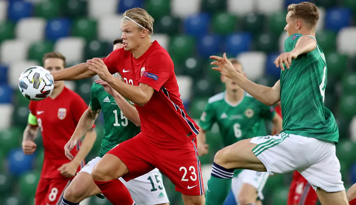 Penyerang Norwegia, Erling Braut Haaland, berebut bola dengan bek Irlandia Utara, Daniel Ballard, pada laga UEFA Nations League di Windsor Park, Selasa (8/9/2020) dini hari WIB. Norwegia menang telak 5-1 atas Irlandia Utara. (AFP/Paul Faith)
