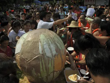  Pengunjung berbagi es krim raksasa berbentuk bola di sebuah resor kolam renang di Tiongkok, Minggu (29/6/14). (REUTERS/Stringer)