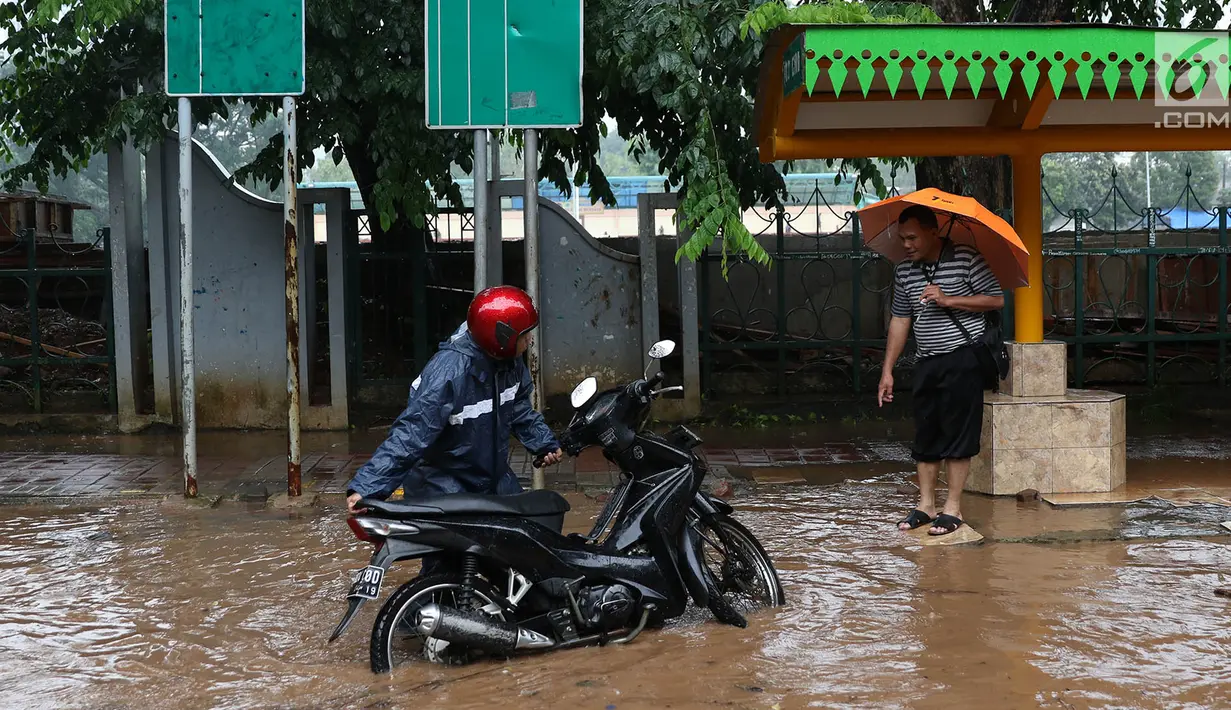 Pengendara motor menepikan kendaraannya saat banjir merendam Jalan Lapangan Banteng Utara, Jakarta, Kamis (15/2). Hujan deras dan buruknya drainase menyebabkan kawasan itu banjir hingga setinggi lutut orang dewasa. (Liputan6.com/Immanuel Antonius)