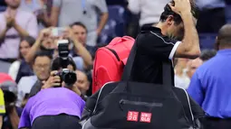 Petenis Roger Federer tertunduk saat berjalan keluar lapangan usai kalah dari Grigor Dimitrov pada perempat final turnamen tenis AS Terbuka 2019 di New York, Amerika Serikat, Selasa (3/9/2019). Dimitrov menang 3-6, 6-4, 6-3, 6-4, 6-2. (AP Photo/Charles Krupa)