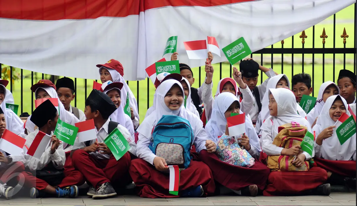 Pelajar SD bersiap menyambut kedatangan Raja Arab Saudi, Salman bin Abdulaziz di sekitar Istana Bogor, Rabu (1/3). Rencananya sekitar 50.000 pelajar akan berjajar untuk menyambut kedatangan Raja Arab dan Presiden Jokowi. (Liputan6.com/Helmi Fithriansyah)