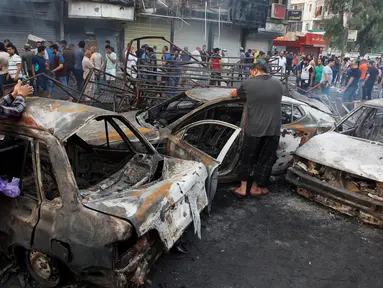 Sejumlah mobil hangus terbakar usai terkena aksi bom bunuh diri di kawasan ramai di sekitar pusat perbelanjaan Karrada di Baghdad, Irak, (3/7). Serangan bom bunuh diri tersebut dilakukan dengan menggunakan mobil. (REUTERS/Khalid al Mousily)