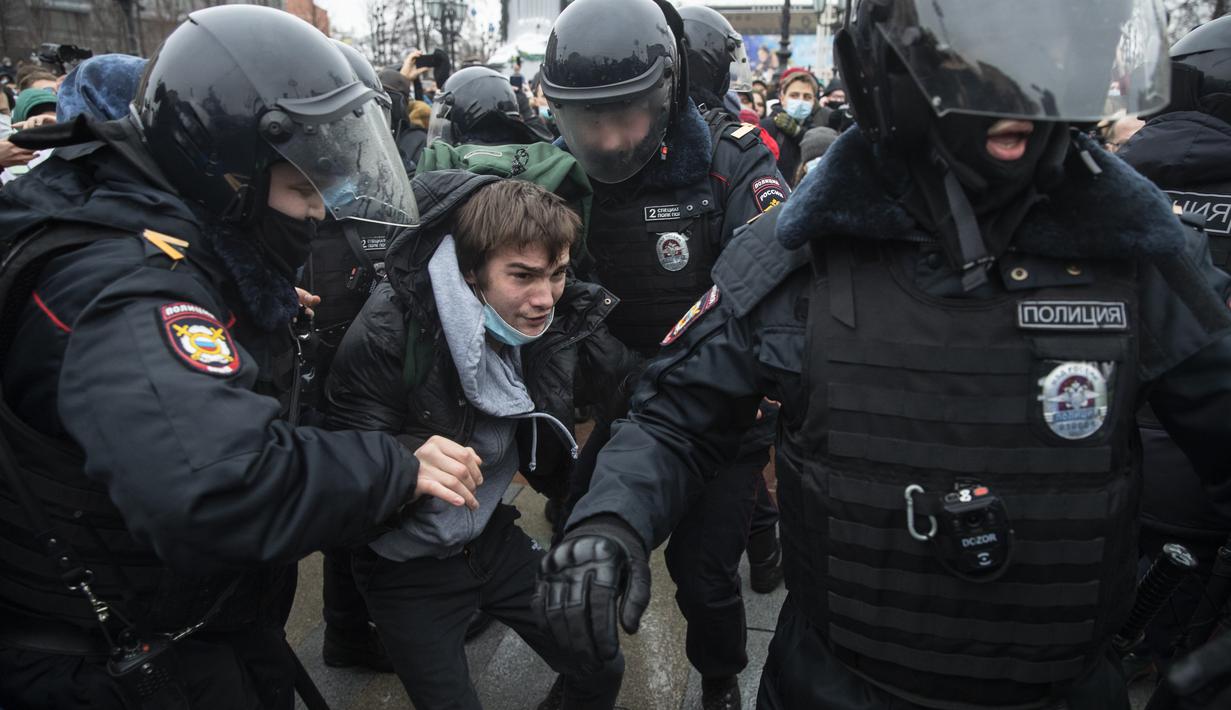 Petugas polisi menahan seorang pria selama protes terhadap pemenjaraan pemimpin oposisi Alexei Navalny di Moskow, Rusia, Sabtu (23/1/2021). 795 penangkapan dilakukan di ibu kota Moskow. (AP Photo/Pavel Golovkin)