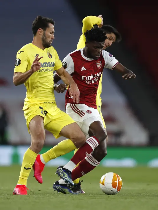Pemain Villareal, Alfonso Pedraza dan Gerard Moreno bersaing dengan gelandang Arsenal, Thomas Partey pada leg kedua semifinal Liga Europa di Emirates Stadium, Jumat (7/5/2021) dinihari. Villarreal menyingkirkan Arsenal dan lolos ke final setelah mencatatakan skor imbang 0-0 (AP Photo/Alastair Grant)