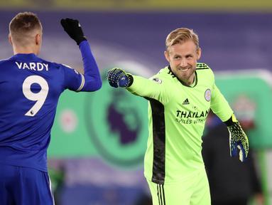 Kiper Leicester City, Kasper Schmeichel (kanan) dan striker Jamie Vardy bersalaman menjelang dimulainya laga lanjutan Liga Inggris 2020/21 pekan ke-18 melawan Southampton di King Power Stadium, Sabtu (16/1/2021). Leicester City menang 2-0 atas Southampton. (AFP/Alex pantling/Pool)